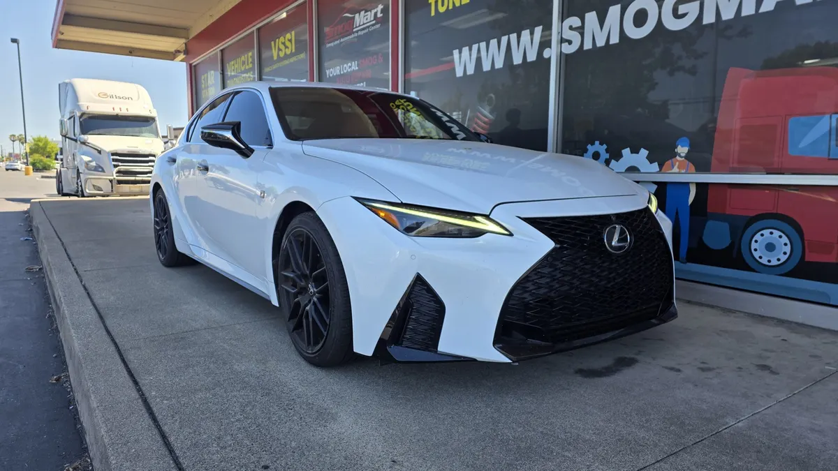 Customer Lexus sedan in front of the Smog Mart bays on Stockton Blvd