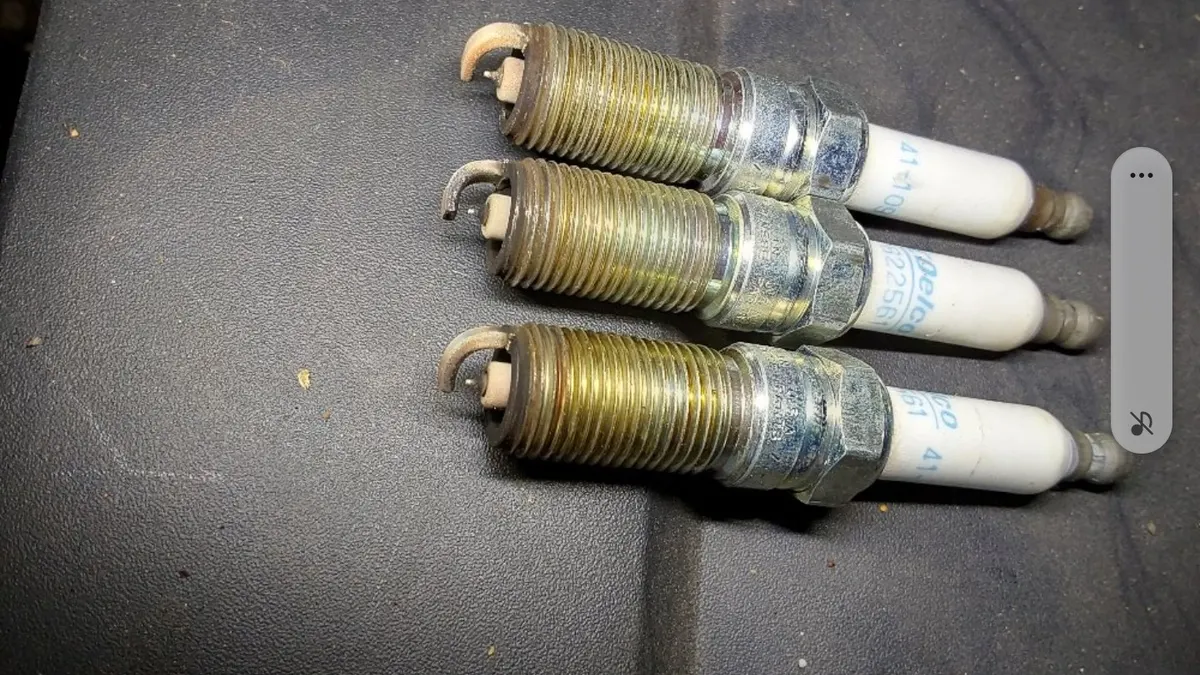 Worn spark plugs removed during a tune-up at Smog Mart