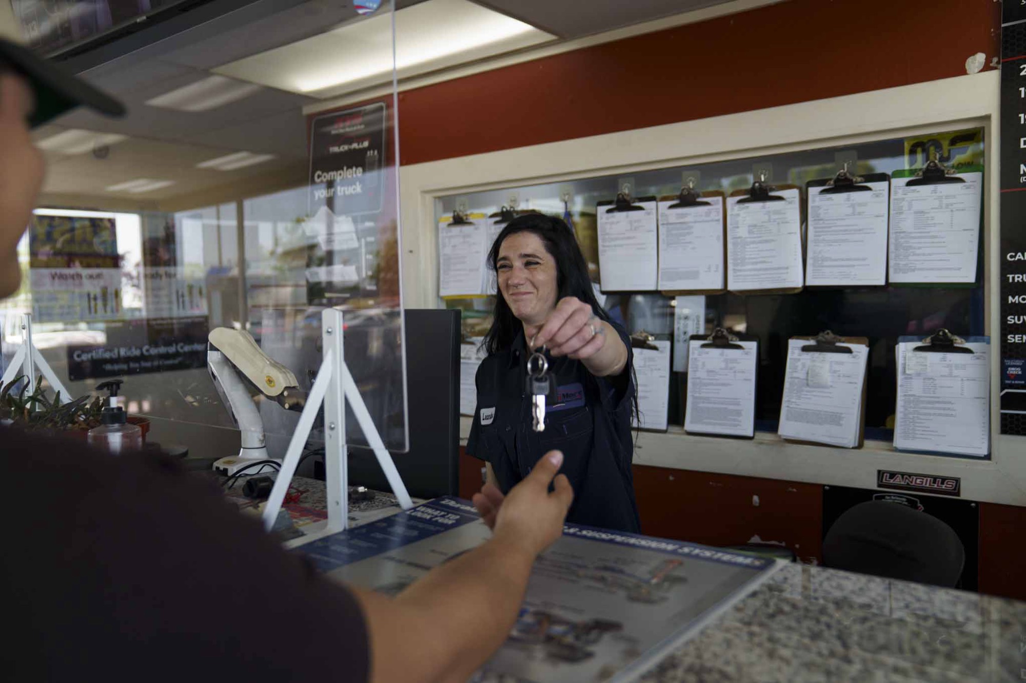 A Smog Mart team member handing keys back to a customer in Sacramento